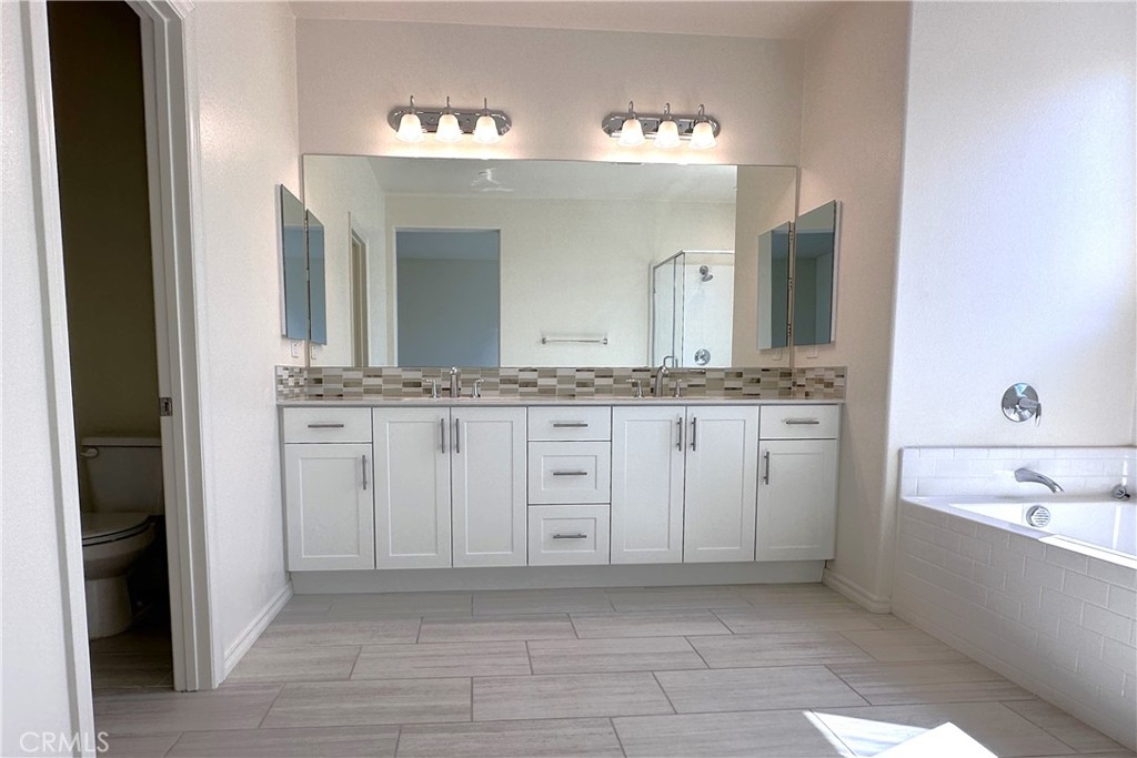 9318 Hellman Avenue, Unit 4 Rancho Cucamonga, CA 91730 - Photo 27 of 28 a spacious bathroom with a granite countertop sink and a mirror