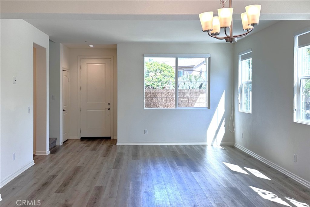 9318 Hellman Avenue, Unit 4 Rancho Cucamonga, CA 91730 - Photo 3 of 28 an empty room with wooden floor and windows