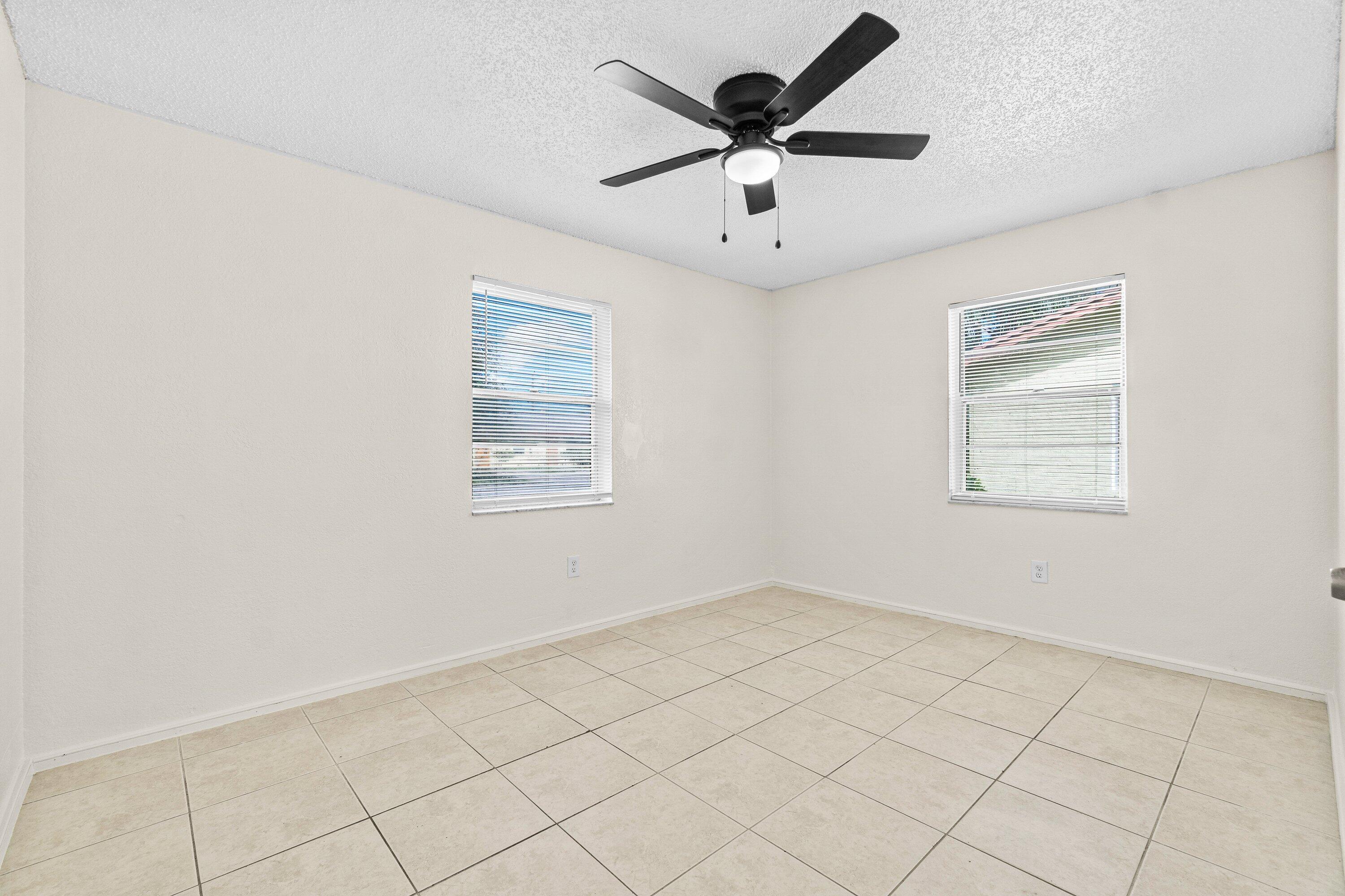 4869 Gulfstream Road Lake Worth, FL 33461 - Photo 13 of 20 wooden floor in an empty room with a window