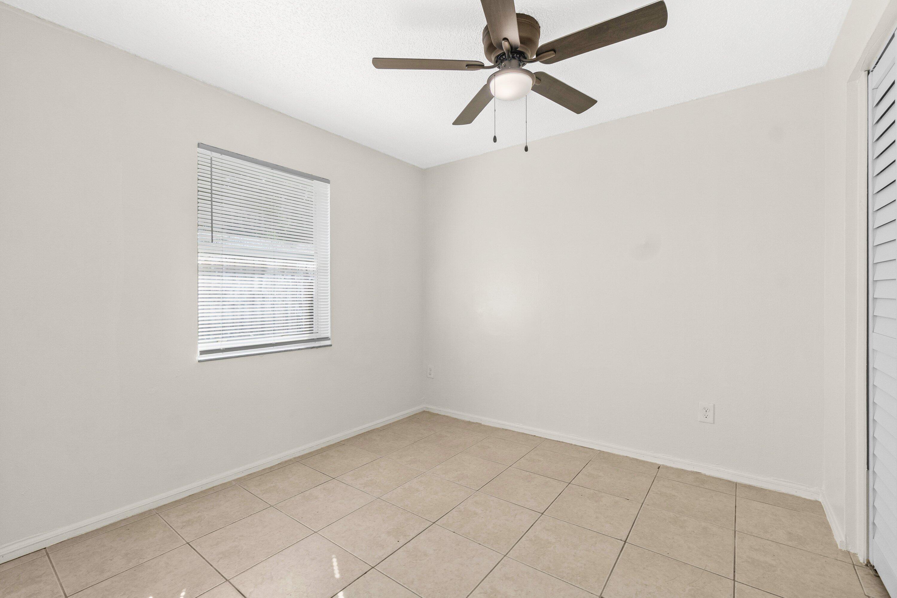 4869 Gulfstream Road Lake Worth, FL 33461 - Photo 17 of 20 an empty room with a window and a fan