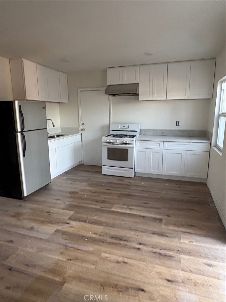10206 South Vermont Avenue Los Angeles, CA 90044 - Photo 2 of 11 a kitchen with a stove and a refrigerator