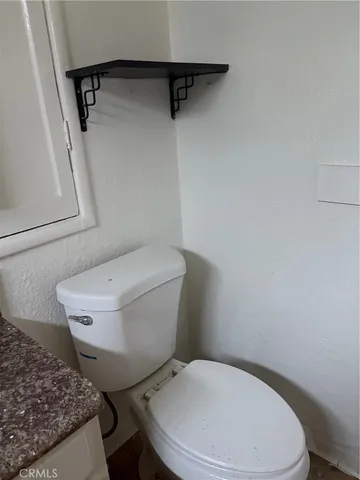 a white toilet sitting next to a small bathroom