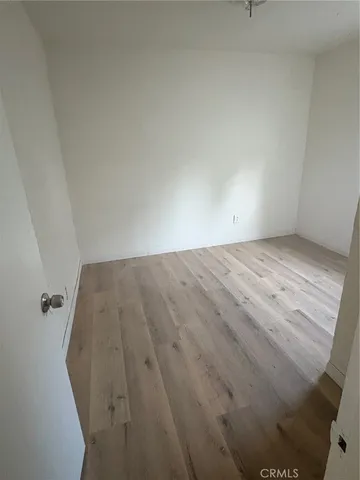 a view of a room with wooden floor and cabinet