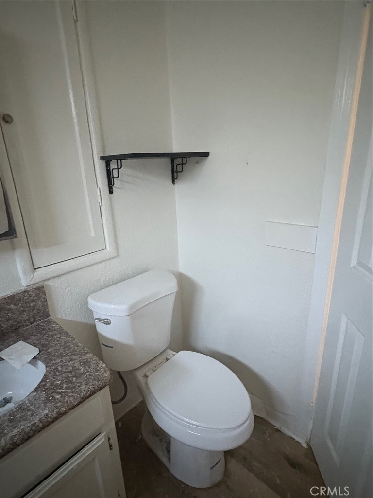 10206 South Vermont Avenue Los Angeles, CA 90044 - Photo 9 of 11 a white toilet sitting next to a sink and vanity