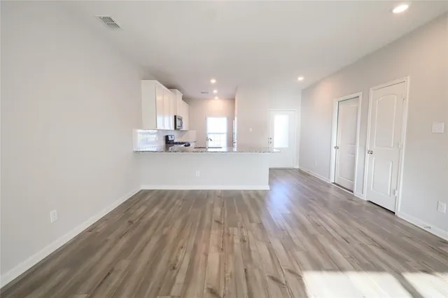 a view of a kitchen with wooden floor and a window
