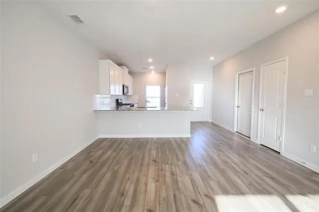 a view of a kitchen with wooden floor and electronic appliances