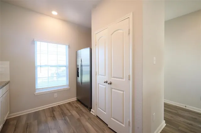 an empty room with wooden floor and a window