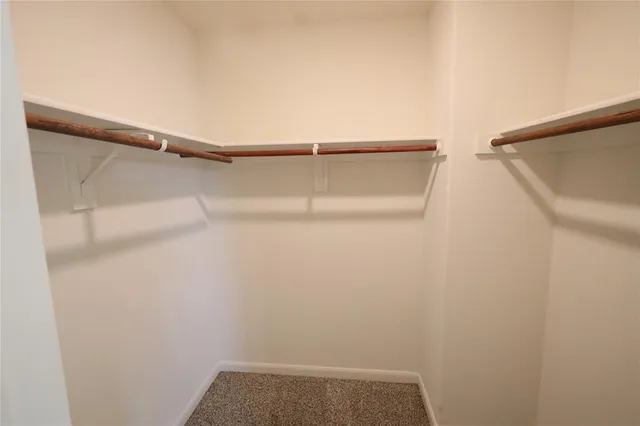 a view of walk in closet with clothes