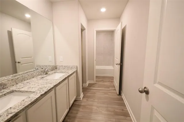 a bathroom with a granite countertop sink and a mirror