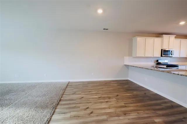 a view of a kitchen with granite countertop cabinets and wooden floor