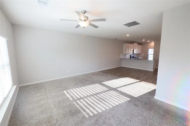 an empty room with kitchen view