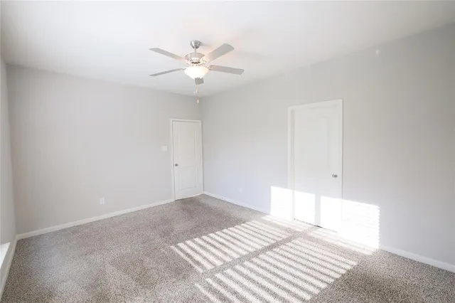 a view of a bedroom with a bed and a chandelier fan