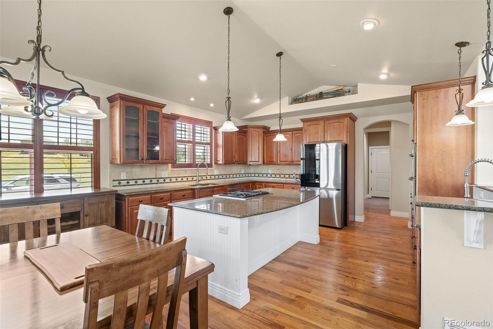 41865 East Muirfield Loop Elizabeth, CO 80107 - Photo 12 of 50 a large kitchen with granite countertop a stove a sink a center island and windows