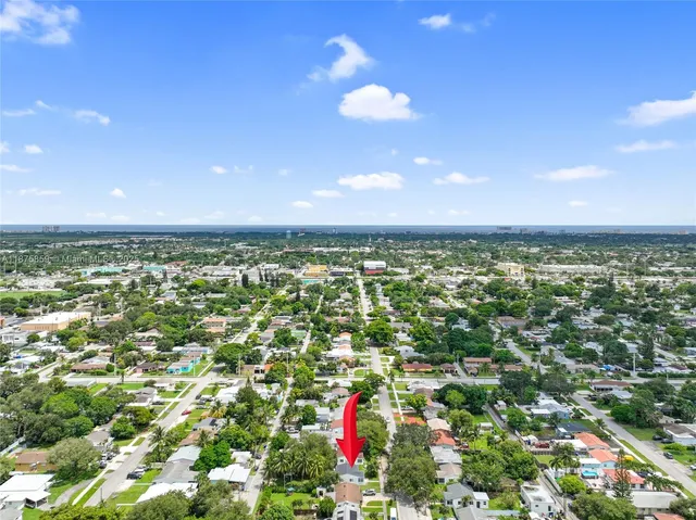 an aerial view of residential houses with outdoor space and trees