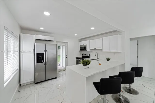 a kitchen with stainless steel appliances a refrigerator and a stove top oven
