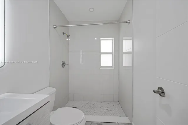 a bathroom with a toilet and a shower