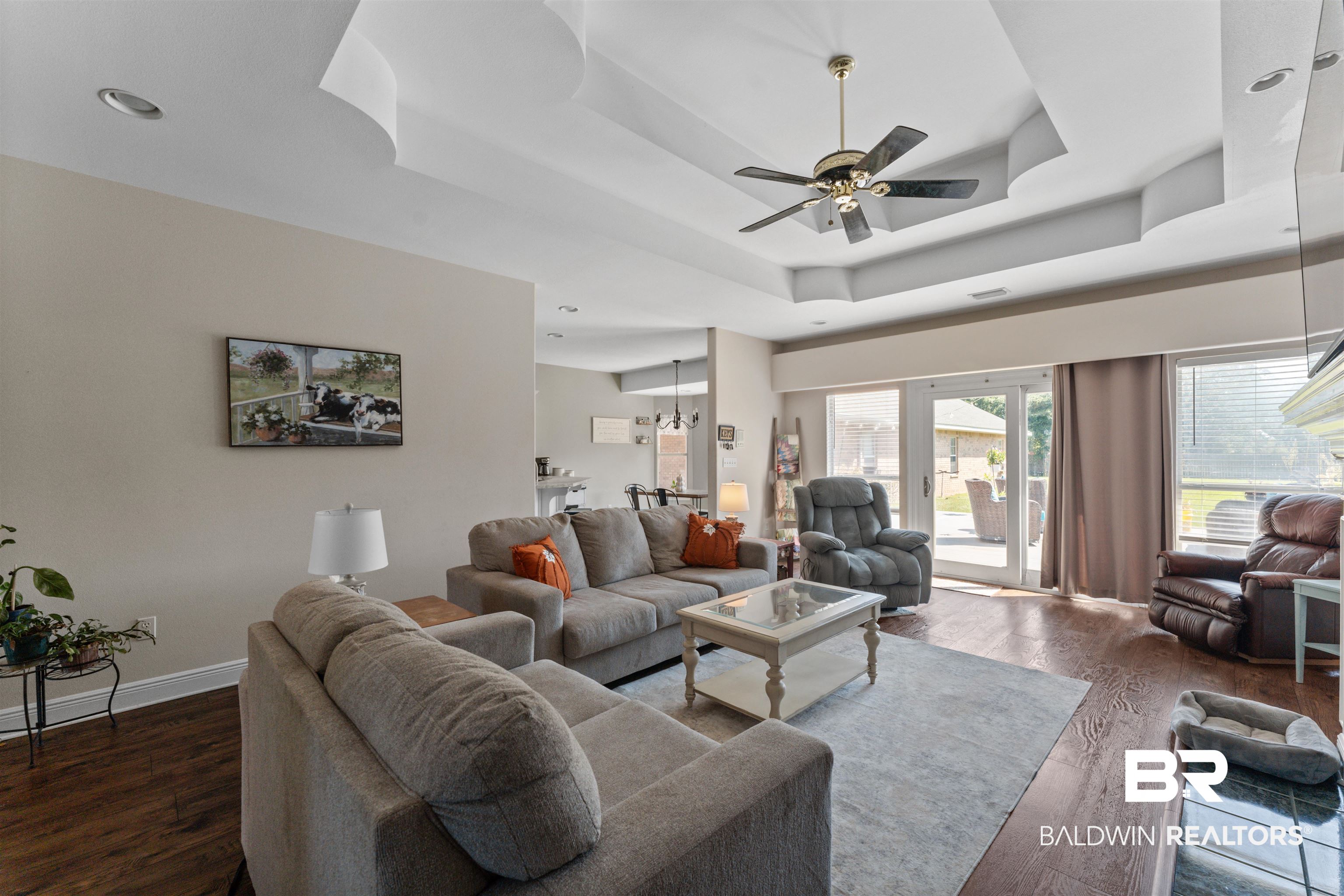 12664 Hunters Chase Foley, AL 36535 - Photo 49 of 62 Living area featuring a tray ceiling, dark wood-style flooring, and ceiling fan