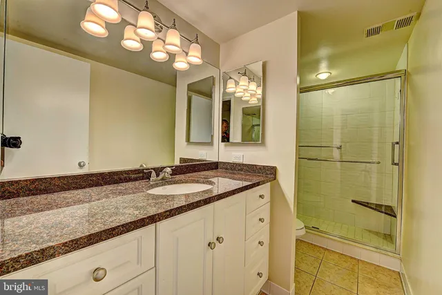 a bathroom with a granite countertop sink and a mirror