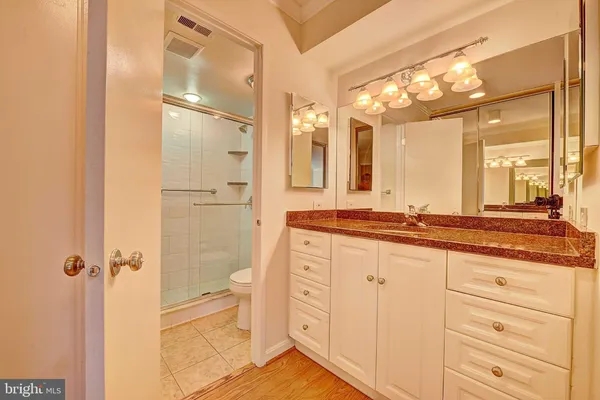 a bathroom with a granite countertop sink mirror and a toilet