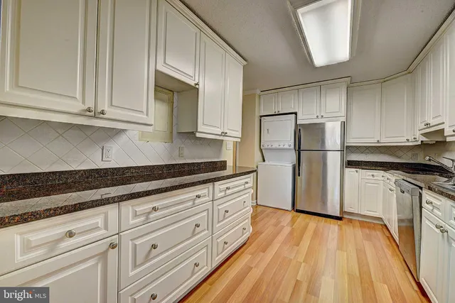 a kitchen with granite countertop white cabinets and stainless steel appliances