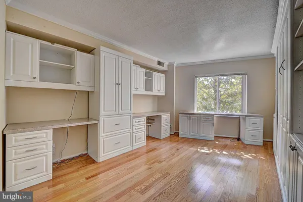a view of a kitchen with wooden floor and cabinets