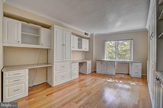 a view of a kitchen with wooden floor and cabinets