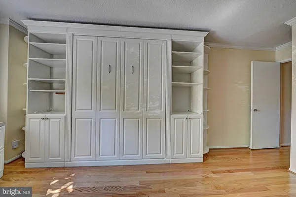 a view of empty room with wooden floor and cabinet
