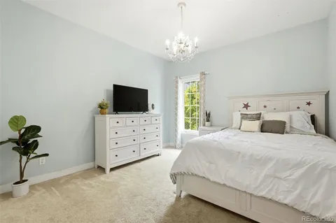 a spacious bedroom with a bed and a flat screen tv