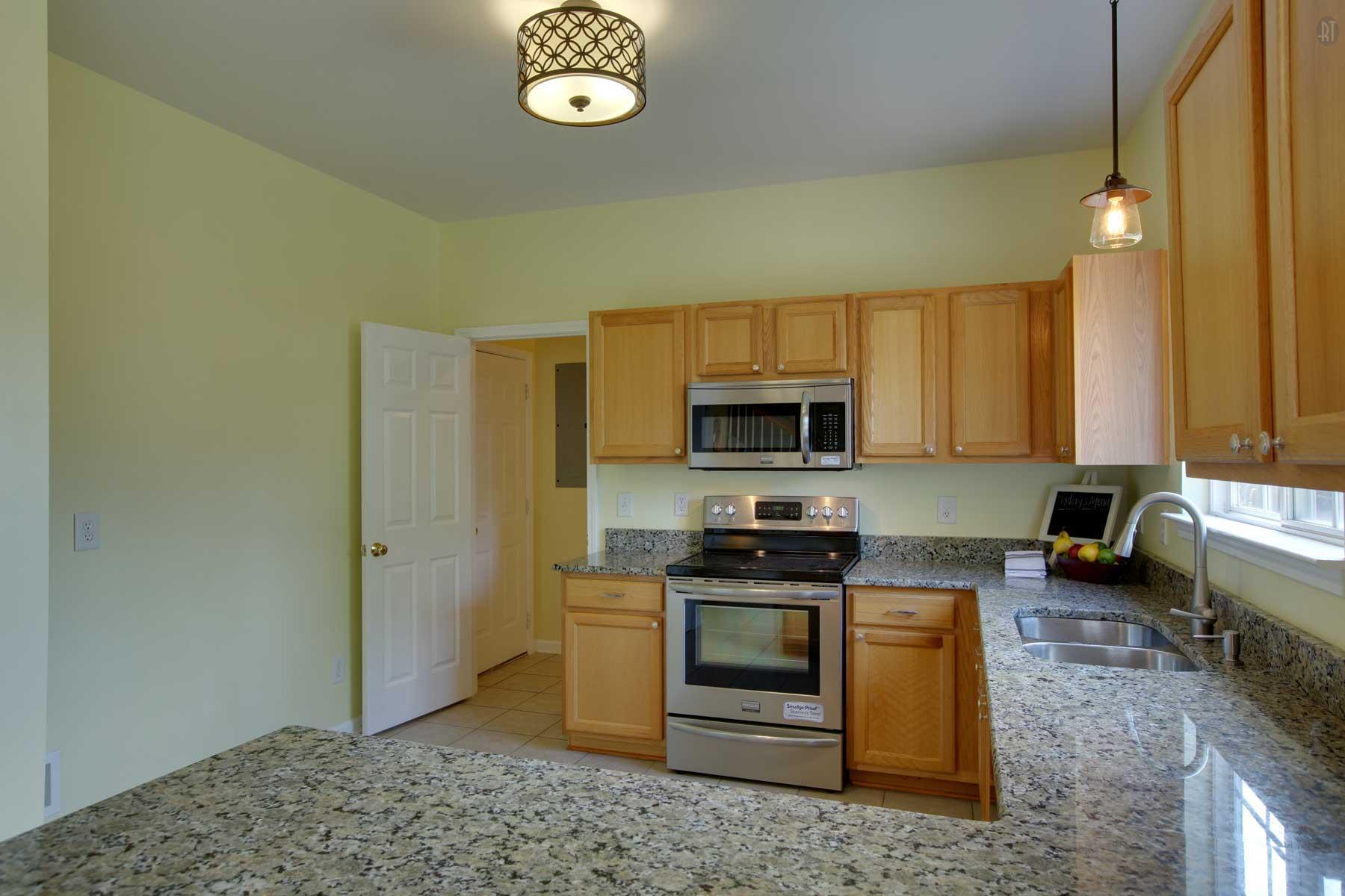 1735 Liberty Pike Franklin, TN 37067 - Photo 15 of 30 a kitchen with stainless steel appliances granite countertop a stove a sink and a microwave