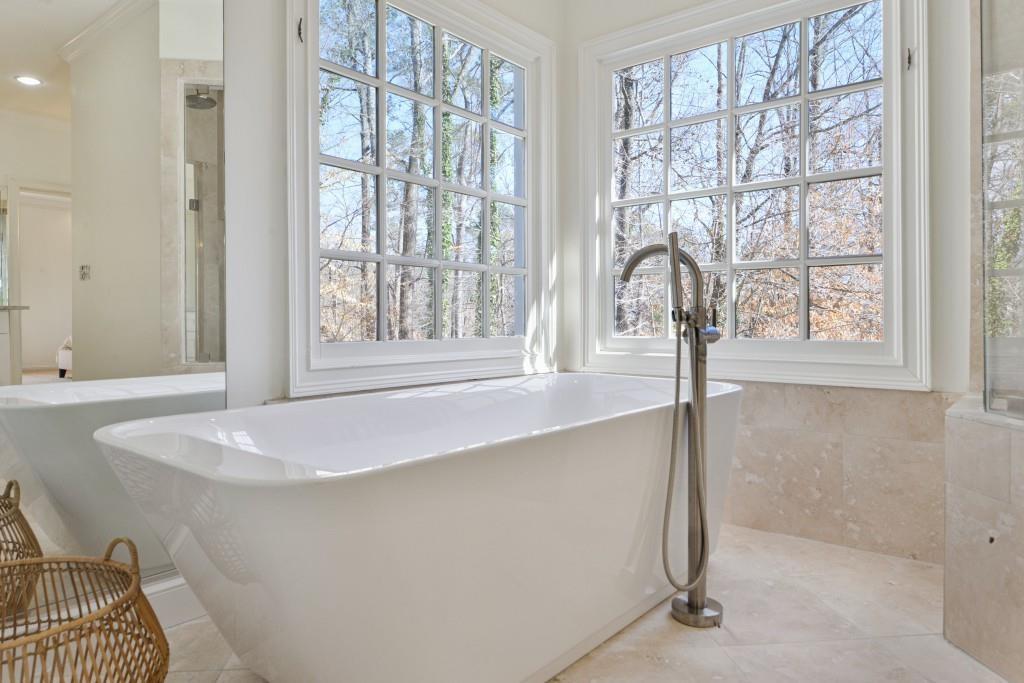 1124 Moores Mill Road Northwest Atlanta, GA 30327 - Photo 23 of 45 a white bath tub sitting in a bathroom next to a window