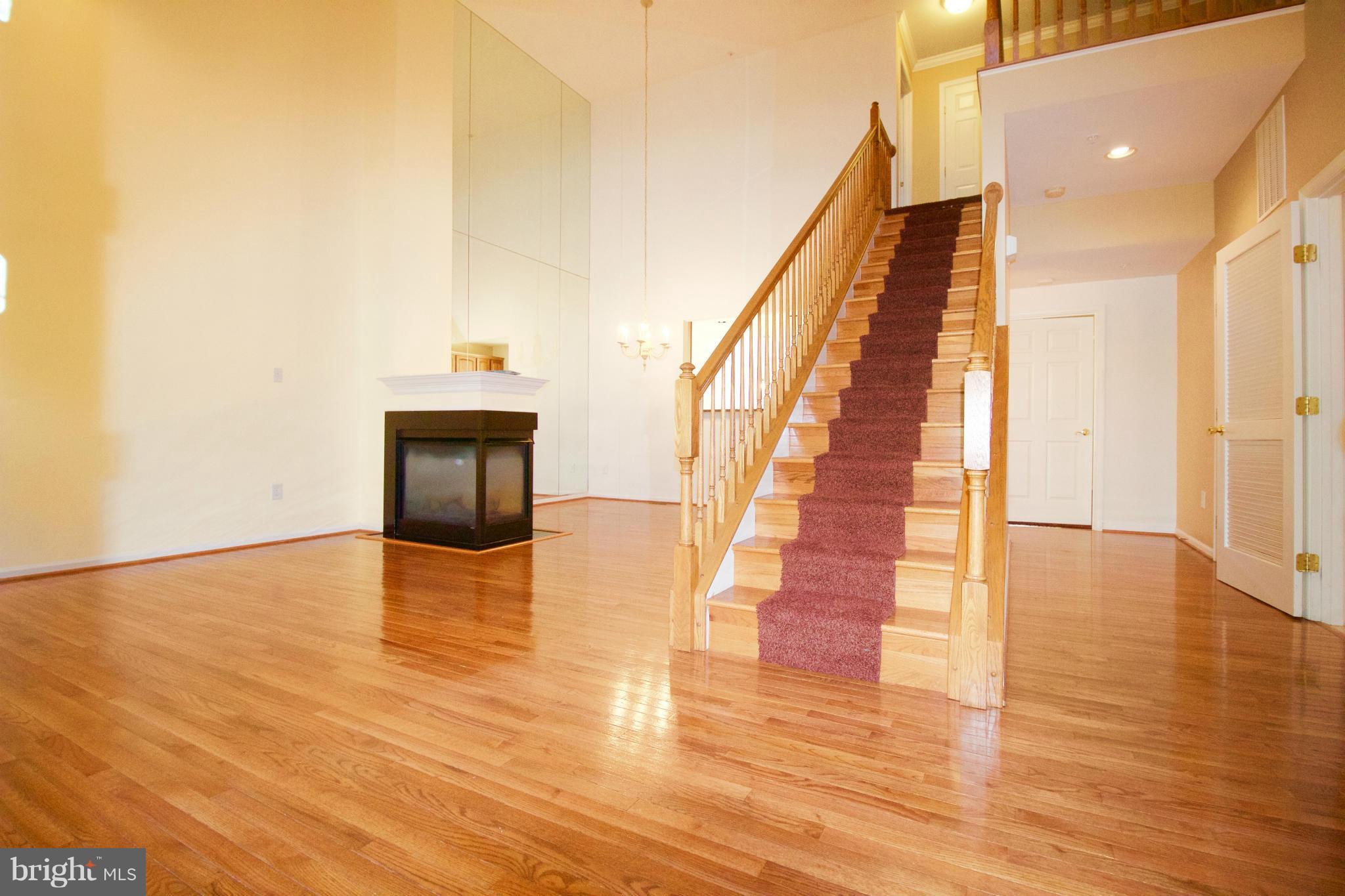 8411 Meadowsweet Road Pikesville, MD 21208 - Photo 2 of 30 a view of an empty room with wooden floor and staircase