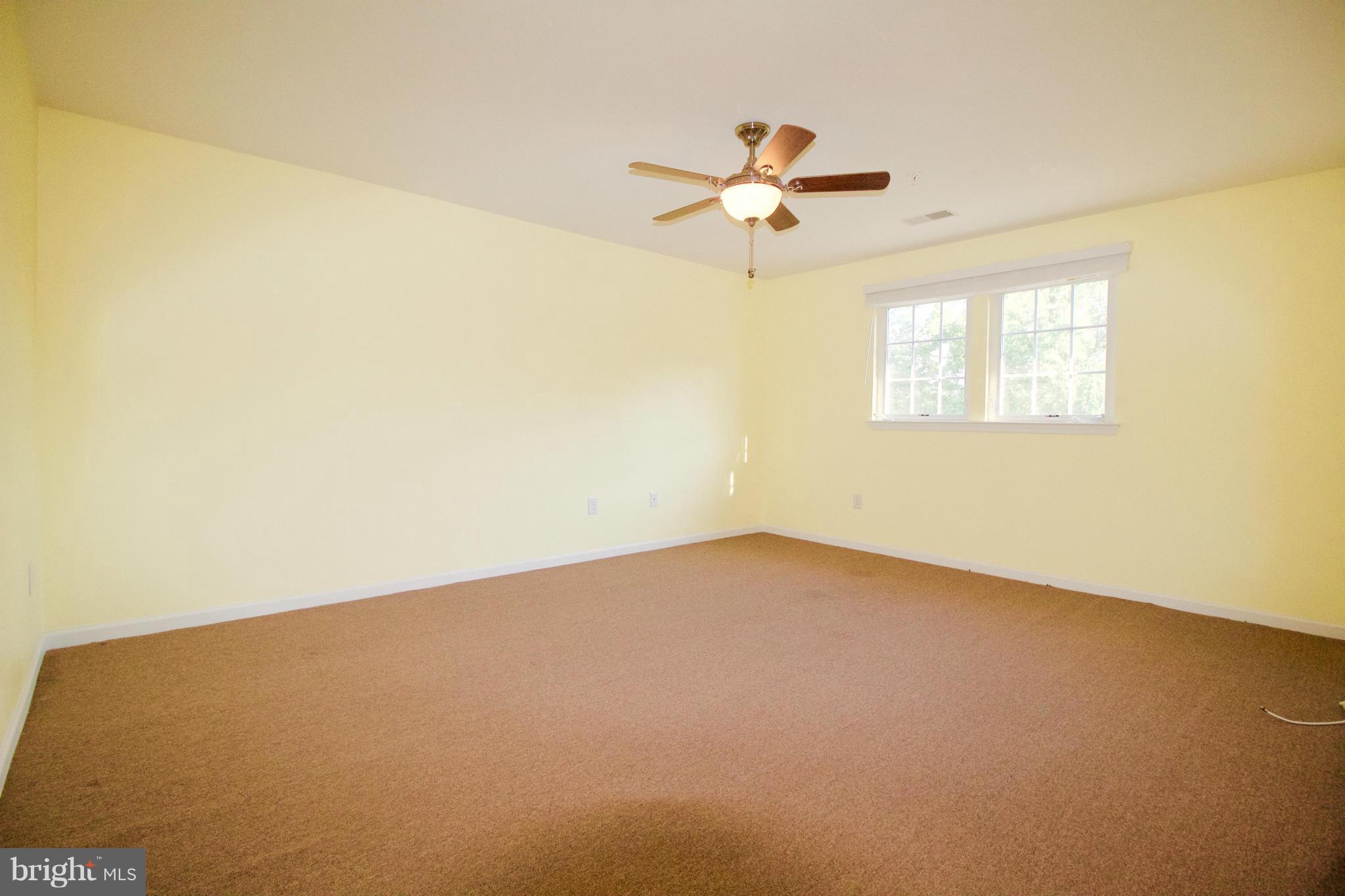 8411 Meadowsweet Road Pikesville, MD 21208 - Photo 17 of 30 an empty room with a window and a chandelier fan