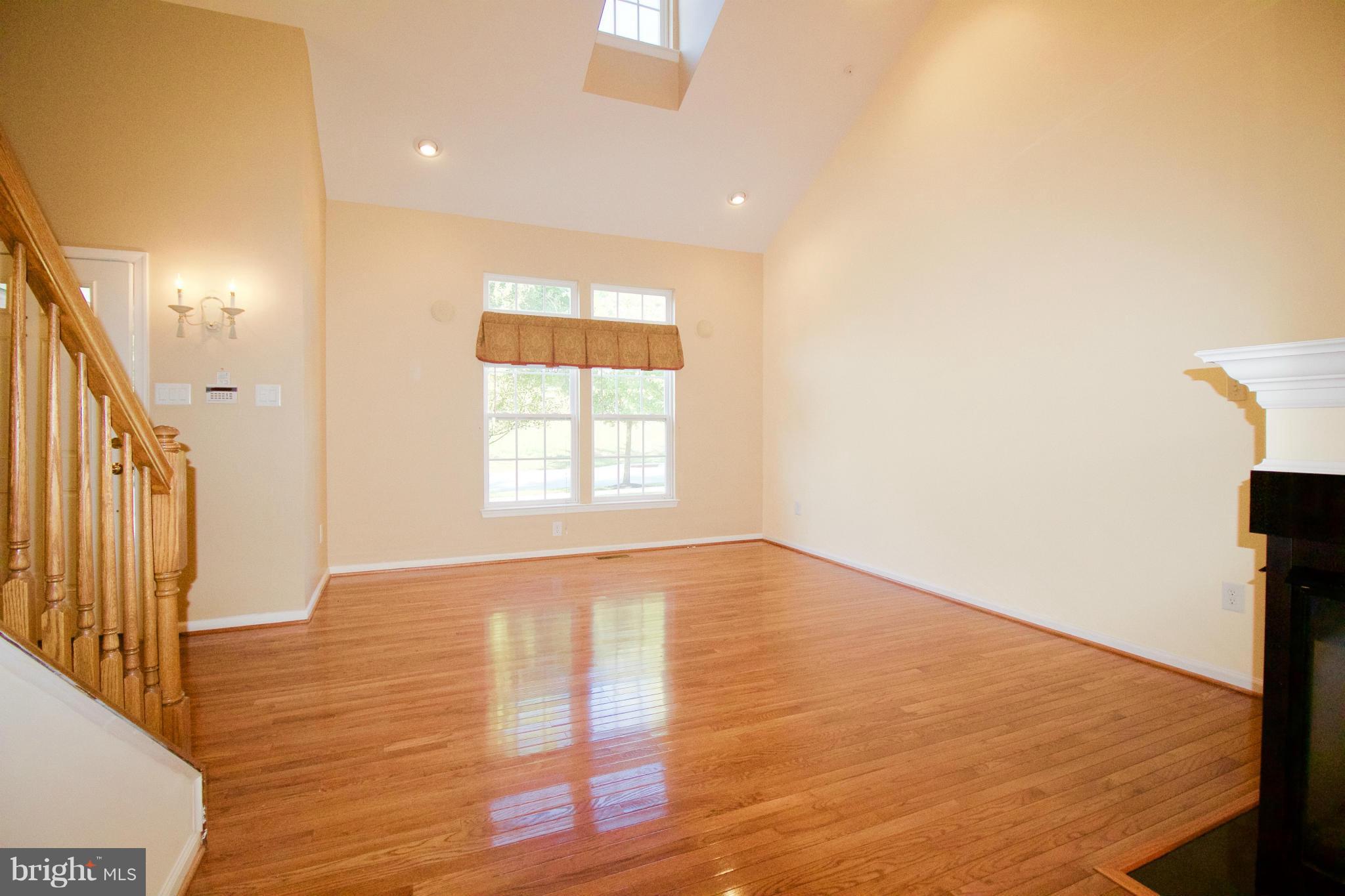 8411 Meadowsweet Road Pikesville, MD 21208 - Photo 4 of 30 a view of an empty room with wooden floor and a window