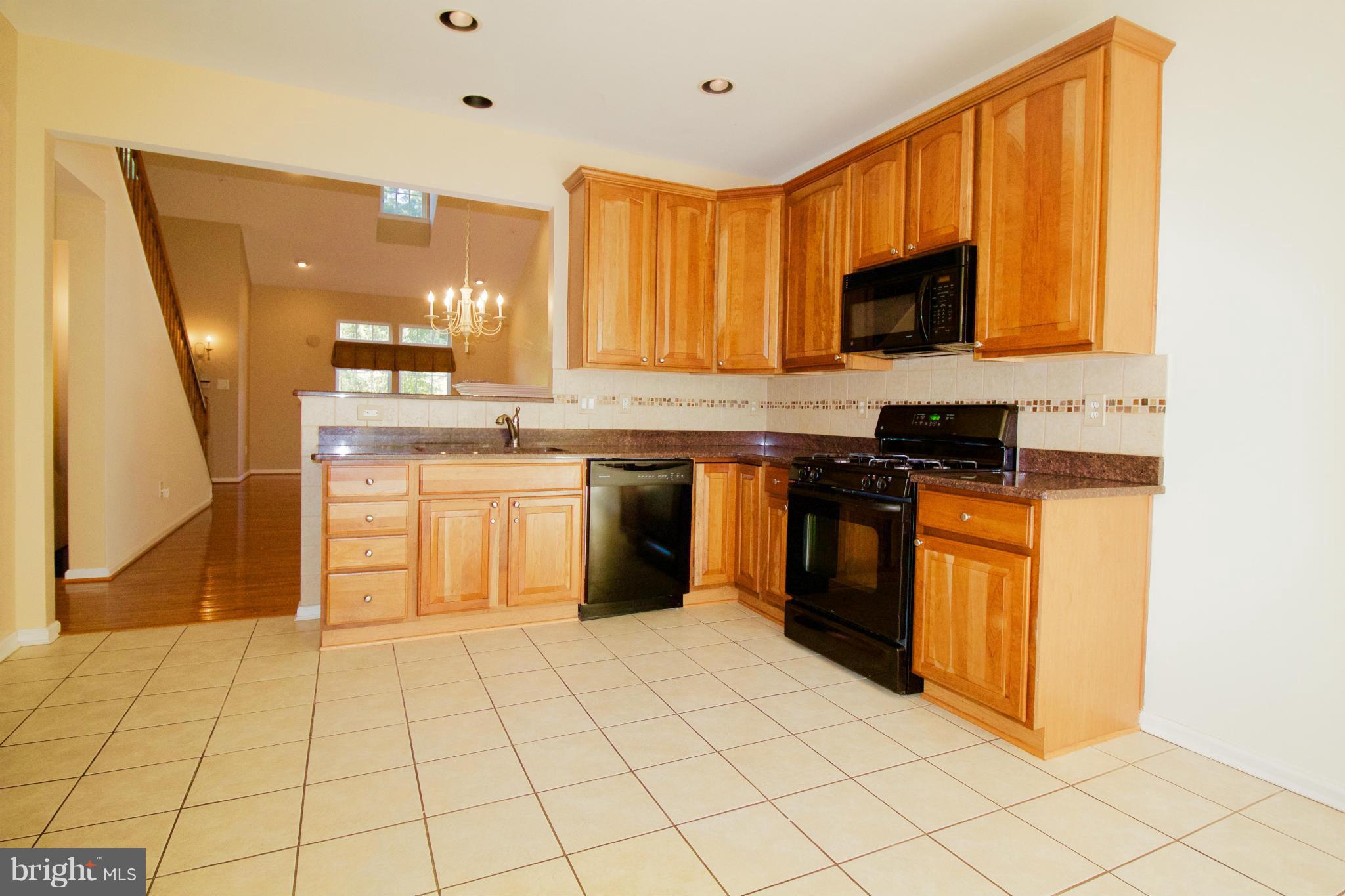 8411 Meadowsweet Road Pikesville, MD 21208 - Photo 7 of 30 a kitchen with stainless steel appliances granite countertop a stove top oven a sink dishwasher and a refrigerator
