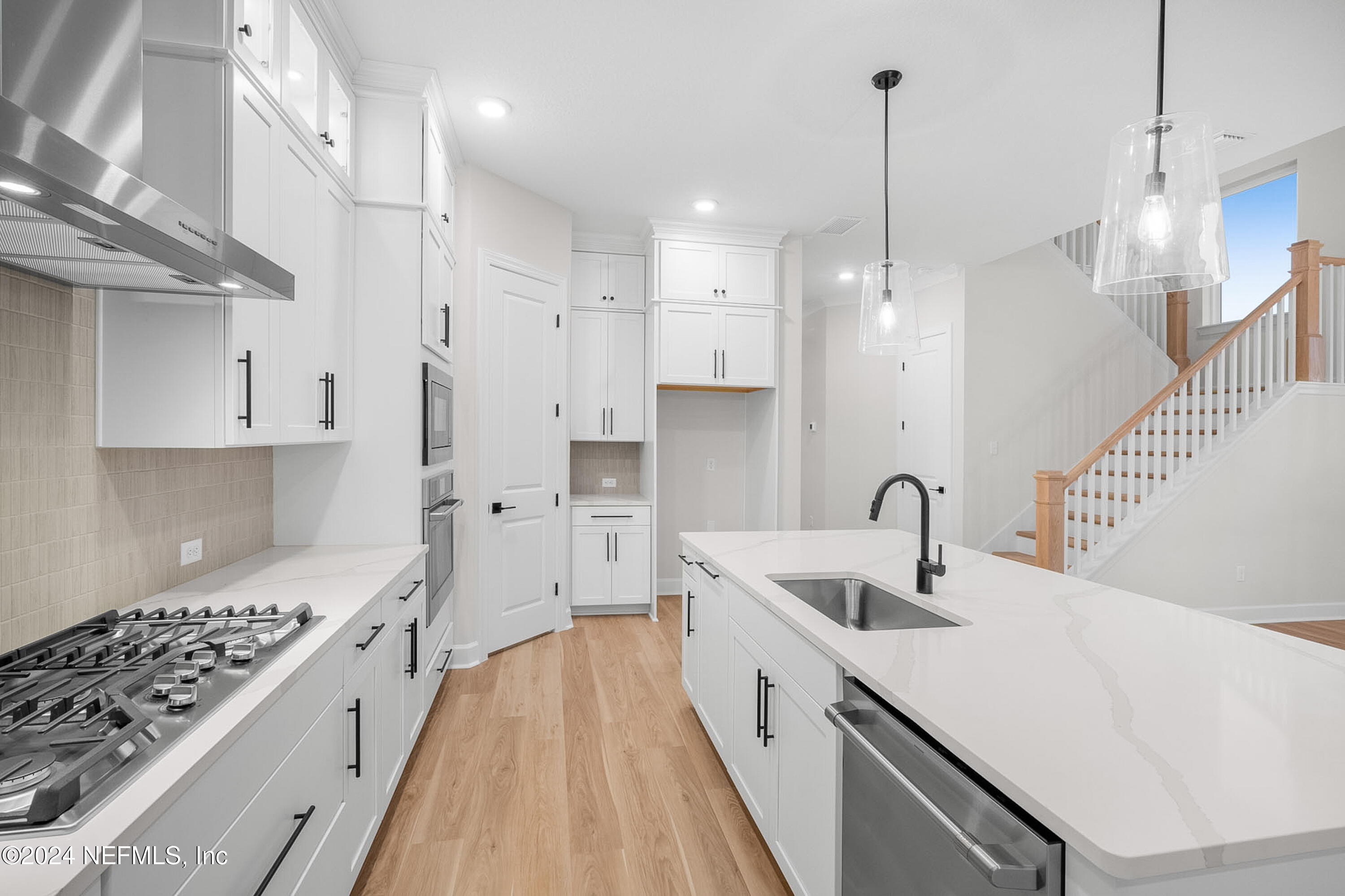 5620 Pathfinder Road Jacksonville, FL 32224 - Photo 3 of 19 a kitchen with white cabinets appliances and a sink