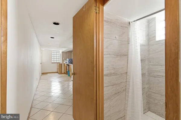 a view of a hallway with wooden cabinets and a bathroom