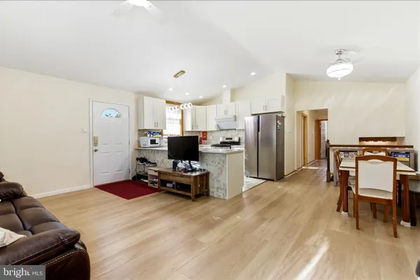 a kitchen with stainless steel appliances refrigerator microwave and dining table