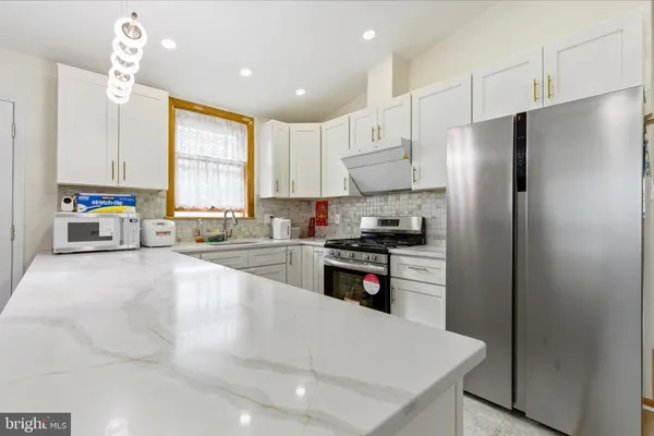 a kitchen with stainless steel appliances a refrigerator sink and cabinets
