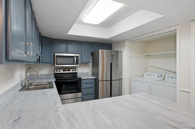 a kitchen with granite countertop a refrigerator and a stove top oven