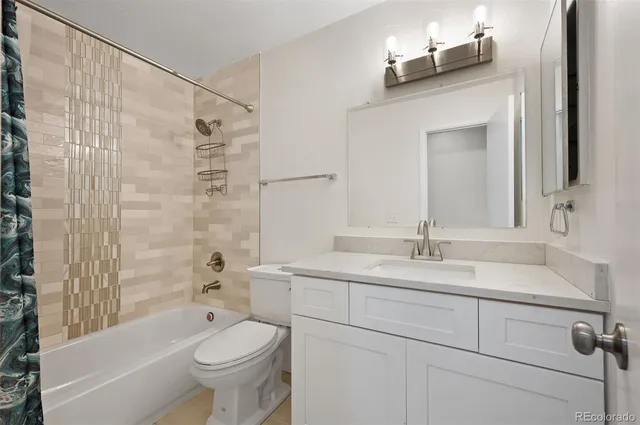 a bathroom with a granite countertop sink toilet and shower