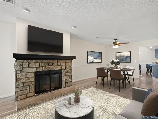 a living room with furniture a flat screen tv and a fireplace