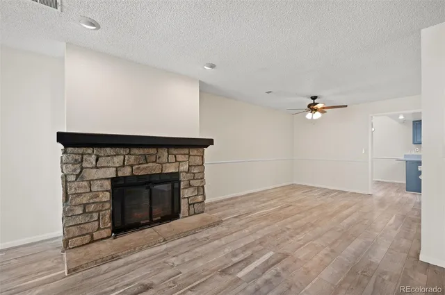 a view of empty room with wooden floor and fireplace