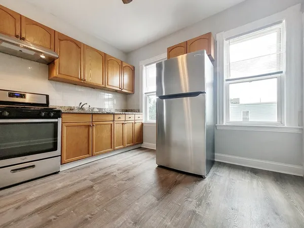 a kitchen with stainless steel appliances granite countertop a refrigerator a sink a stove and cabinets