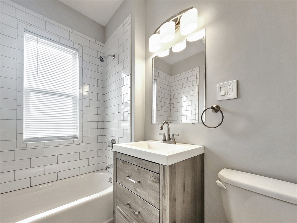 35 Dunlap Street, Unit 3 Boston, MA 02124 - Photo 7 of 9 a bathroom with a double vanity sink mirror and a toilet