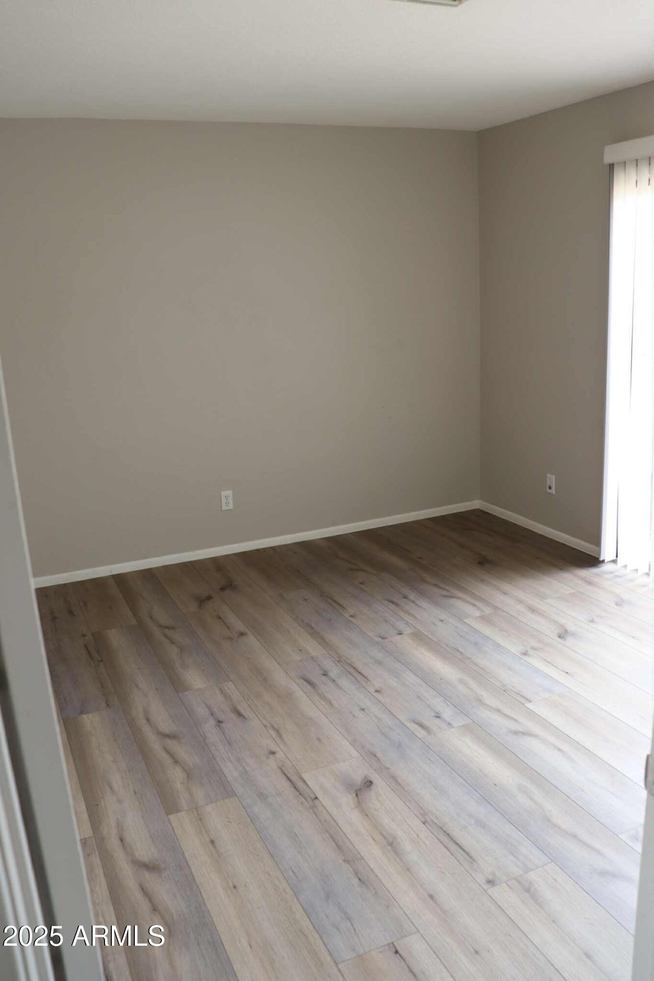 653 West Guadalupe Road, Unit 2005 Mesa, AZ 85210 - Photo 11 of 27 a view of an empty room with wooden floor and a window