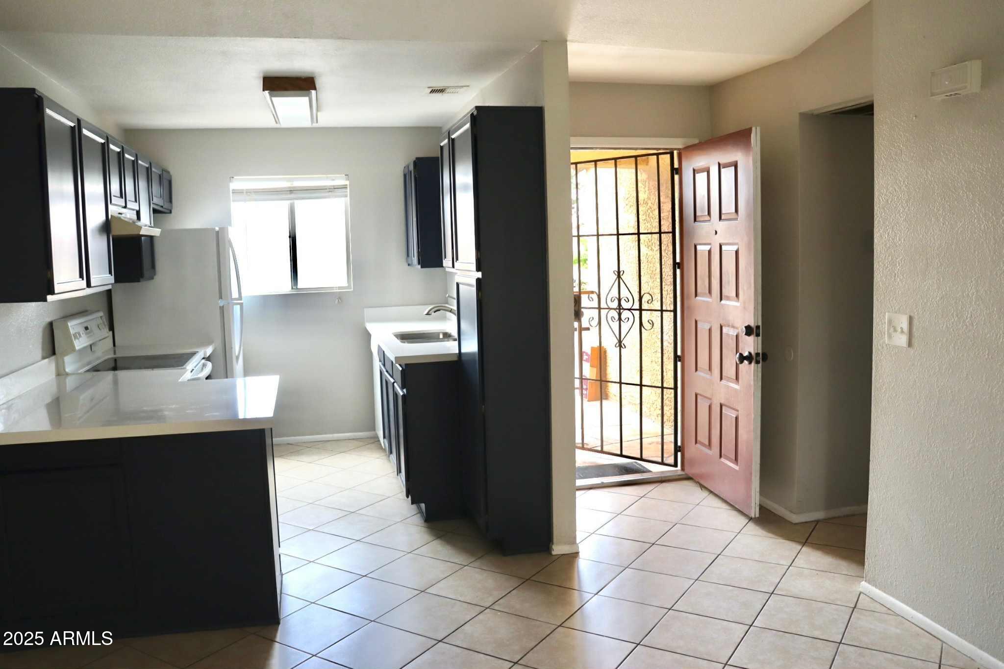 653 West Guadalupe Road, Unit 2005 Mesa, AZ 85210 - Photo 18 of 27 a kitchen with a sink a refrigerator and a window