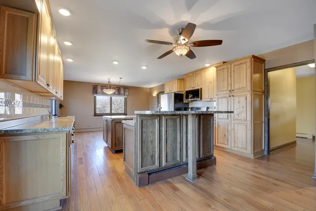 an empty room with wooden floor windows and fireplace