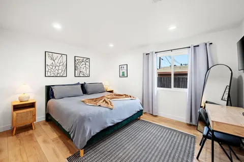 a bedroom with bed and wooden floor