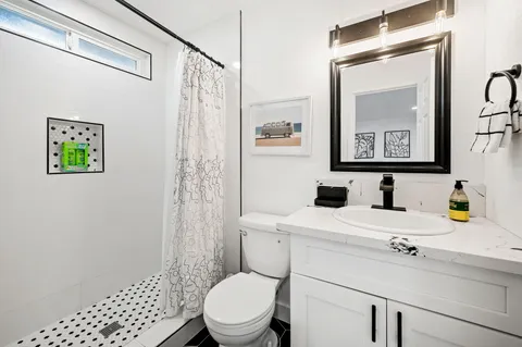 a bathroom with a sink a toilet and shower