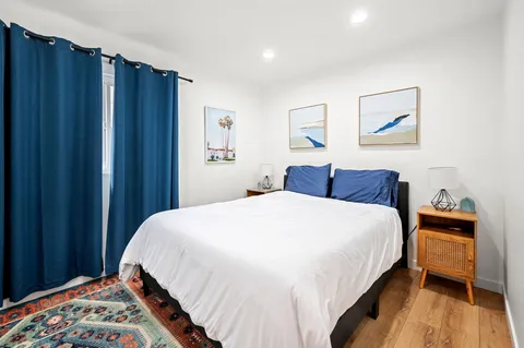 a bedroom with bed and wooden floor